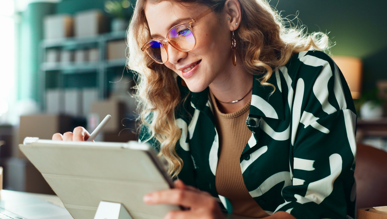 Mulher jovem feliz a escrever no tablet