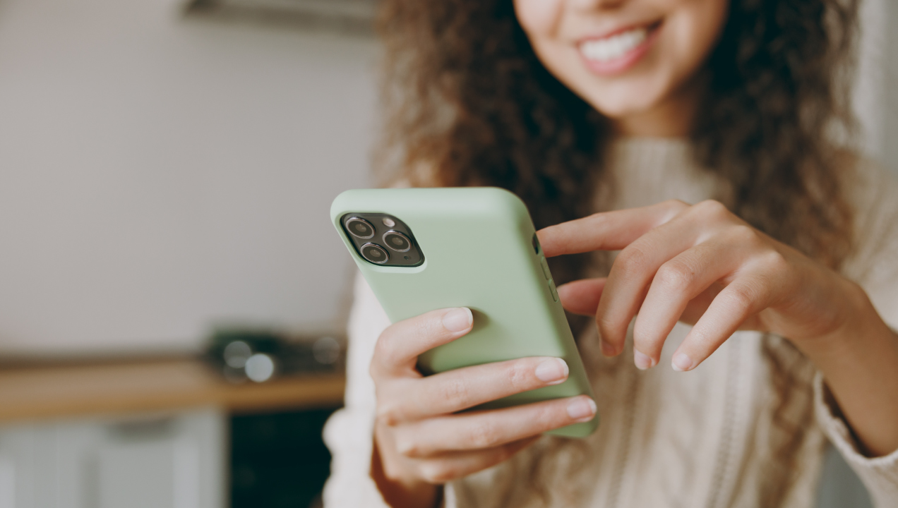 Senhora feliz a mexer no telemóvel