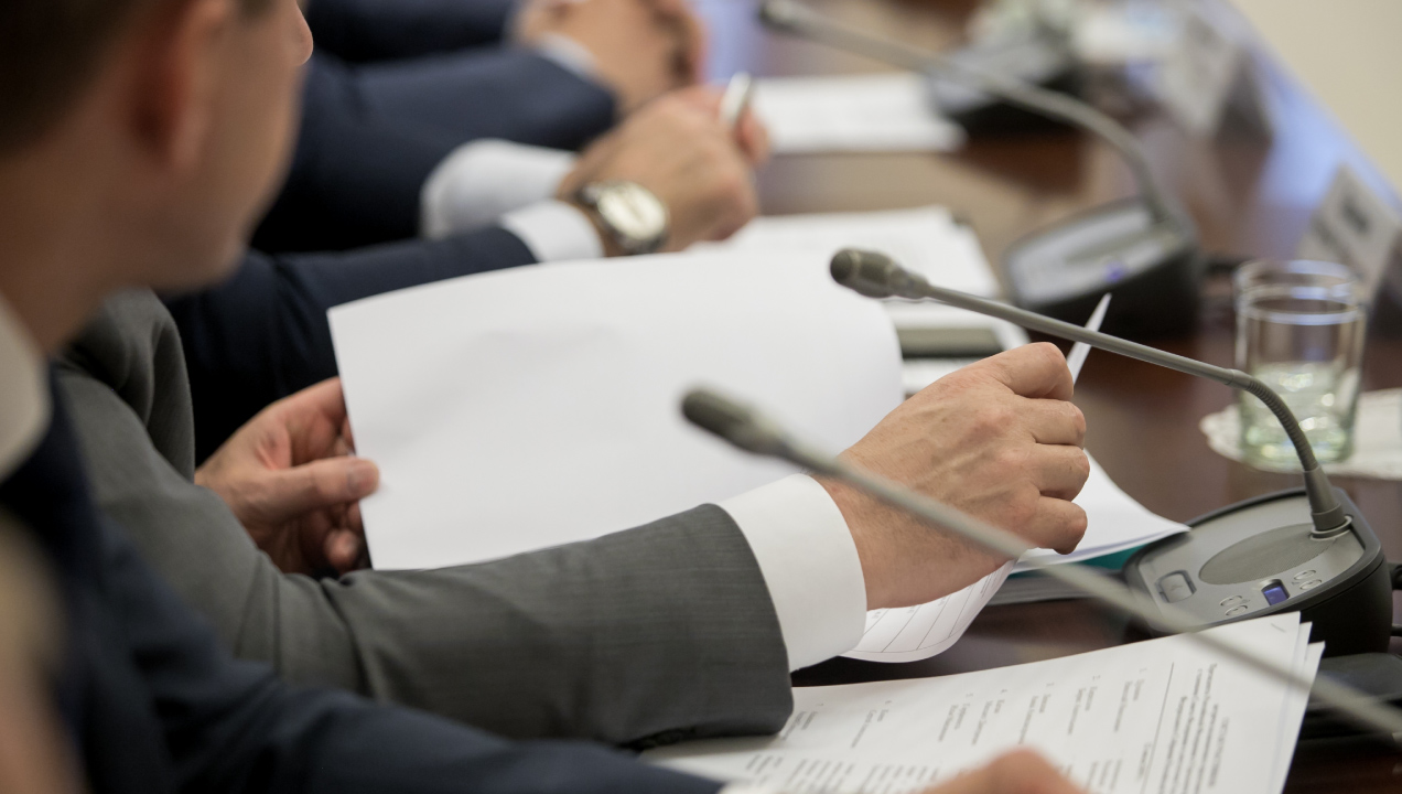 Executivos sentados numa mesa de conferências a segurar e a ler documentos