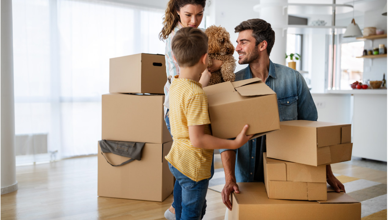 Família a desempacotar caixas de mudanças felizes numa casa nova