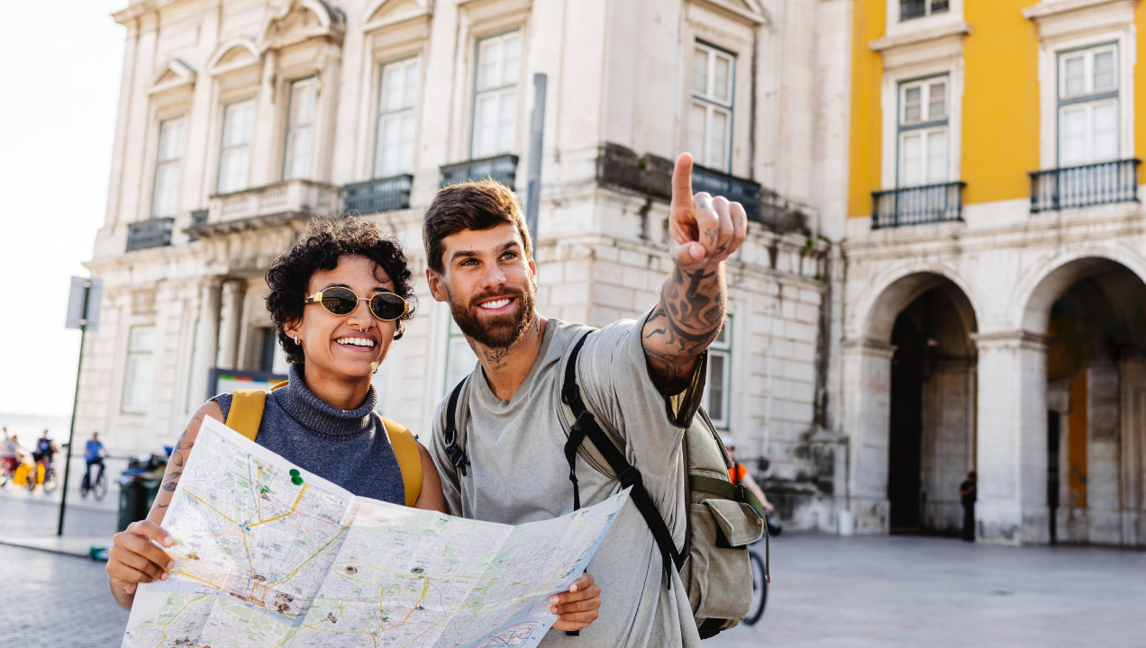 Turistas a passear no terreiro do paço com um mapa 