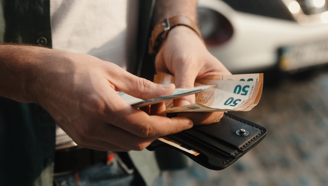 Mãos seguram em dinheiro em notas