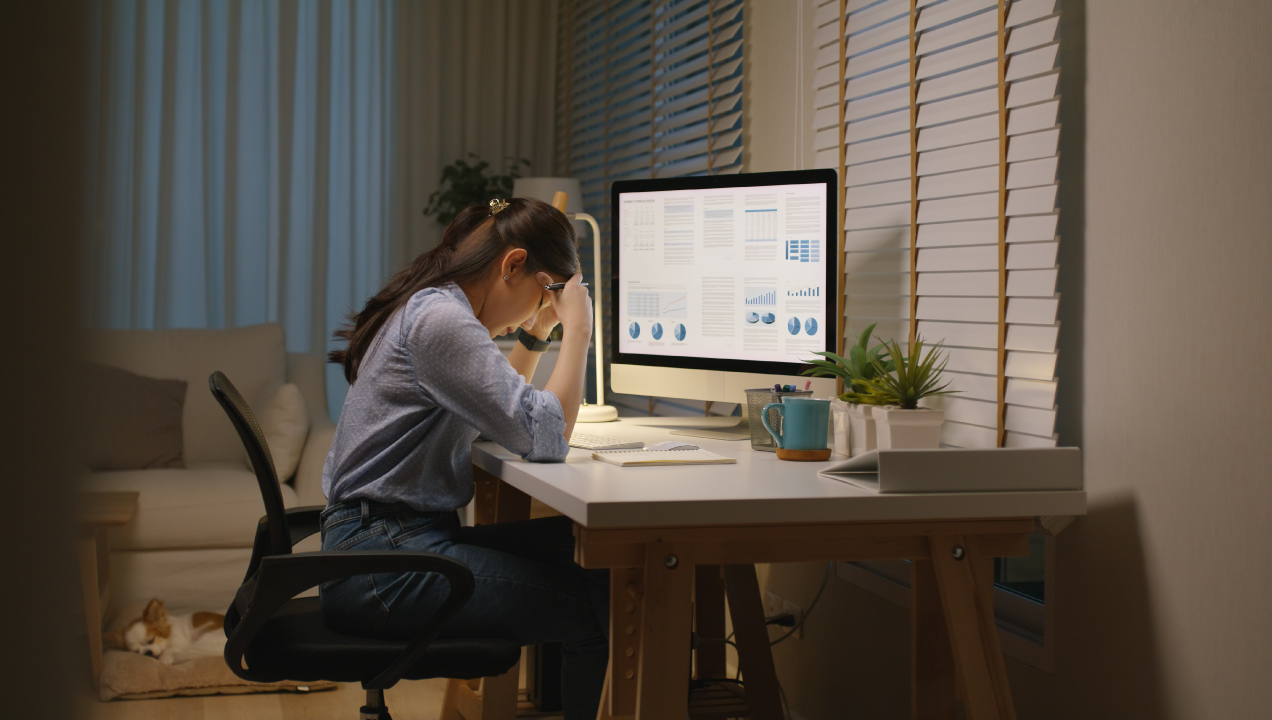 mulher frustrada numa secretária com computador 