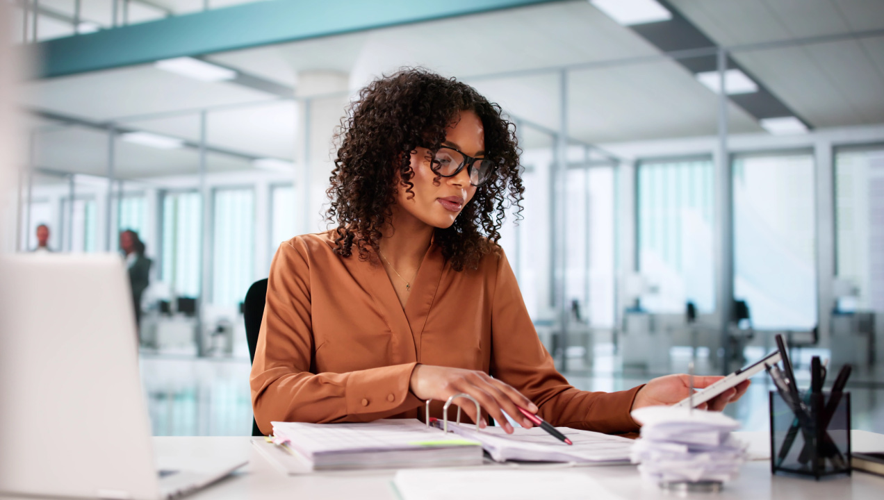 Senhora num escritório a analisar um docier com documentos