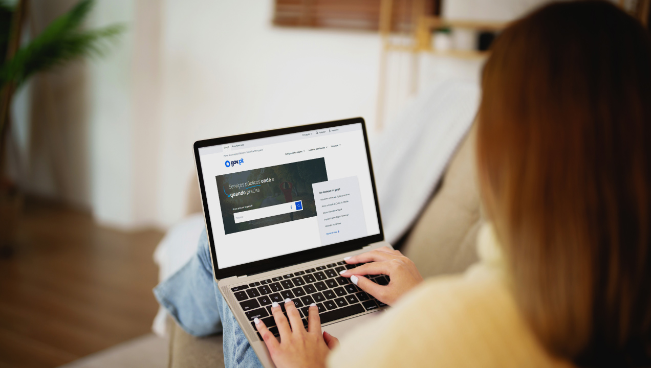 Mulher com computador portátil altera domicílio fiscal no Gov.pt