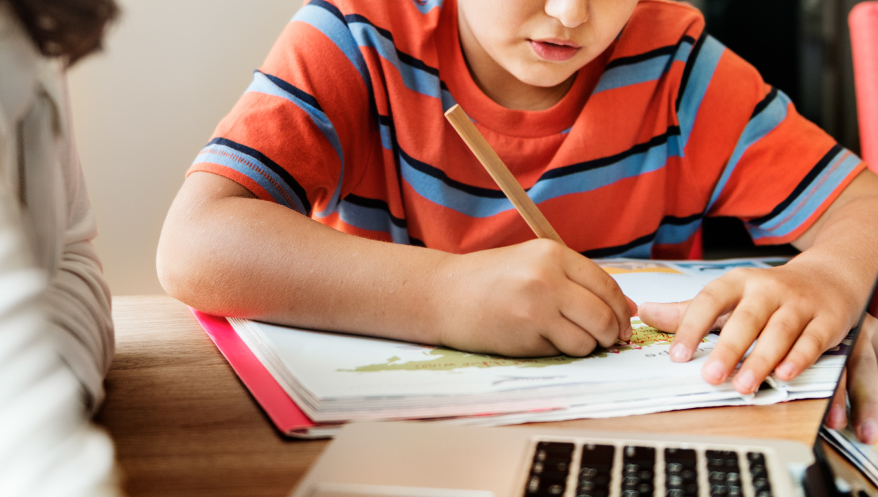 criança a escrever em livro escolar criança a escrever em livro escolar