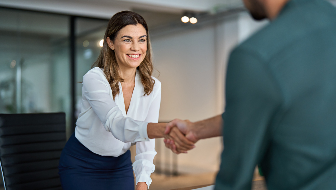 Mulher em ambiente profissional a cumprimentar um colega com passou-bem