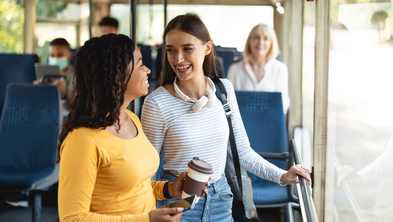 Duas jovens no autocarro a falarem animadas uma com a outra