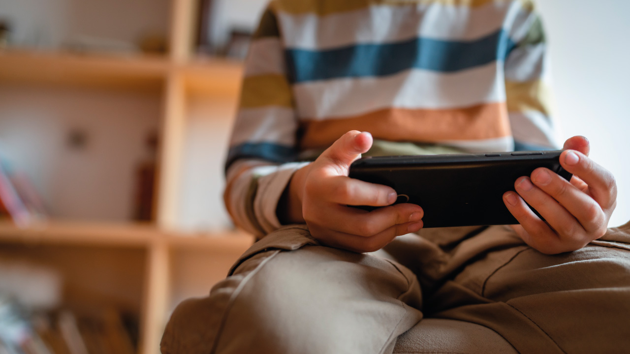 criança com telemóvel na mão