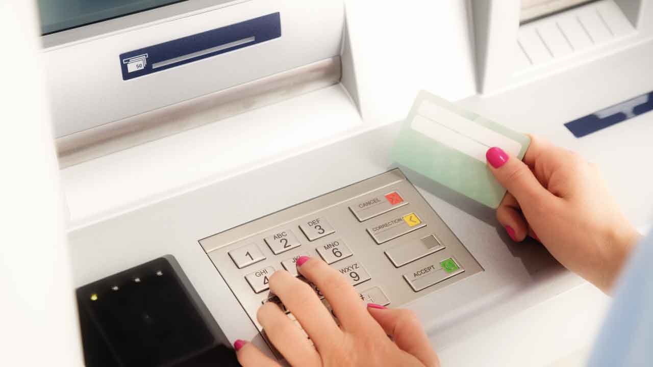 senhora com cartão bancário em ATM