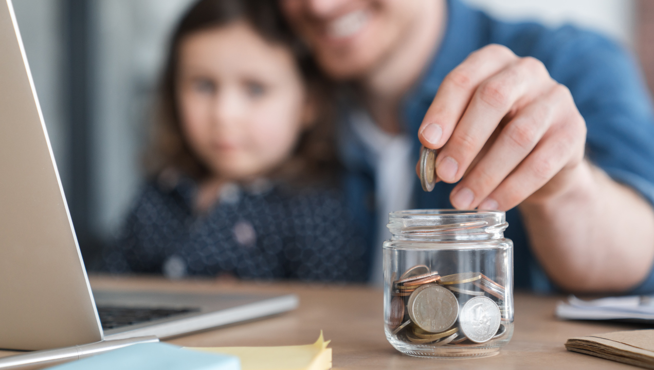 Pai educa filha em literacia financeira contando moedas