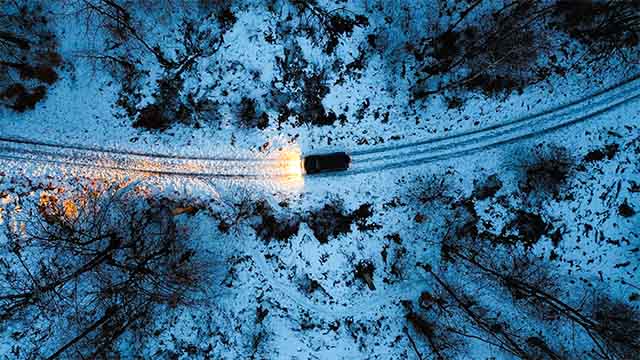 Fotografia de carro a andar em estradas cheias de neve