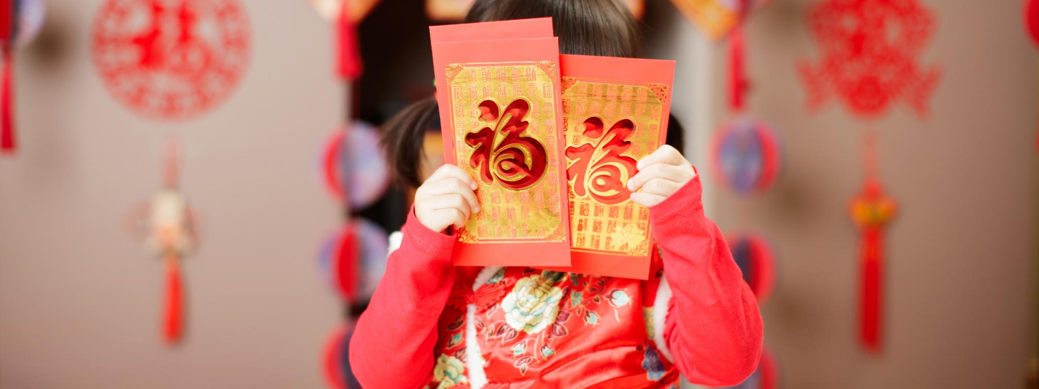  Calendário Chinês: menina segura três cartolinas vermelhas e douradas
