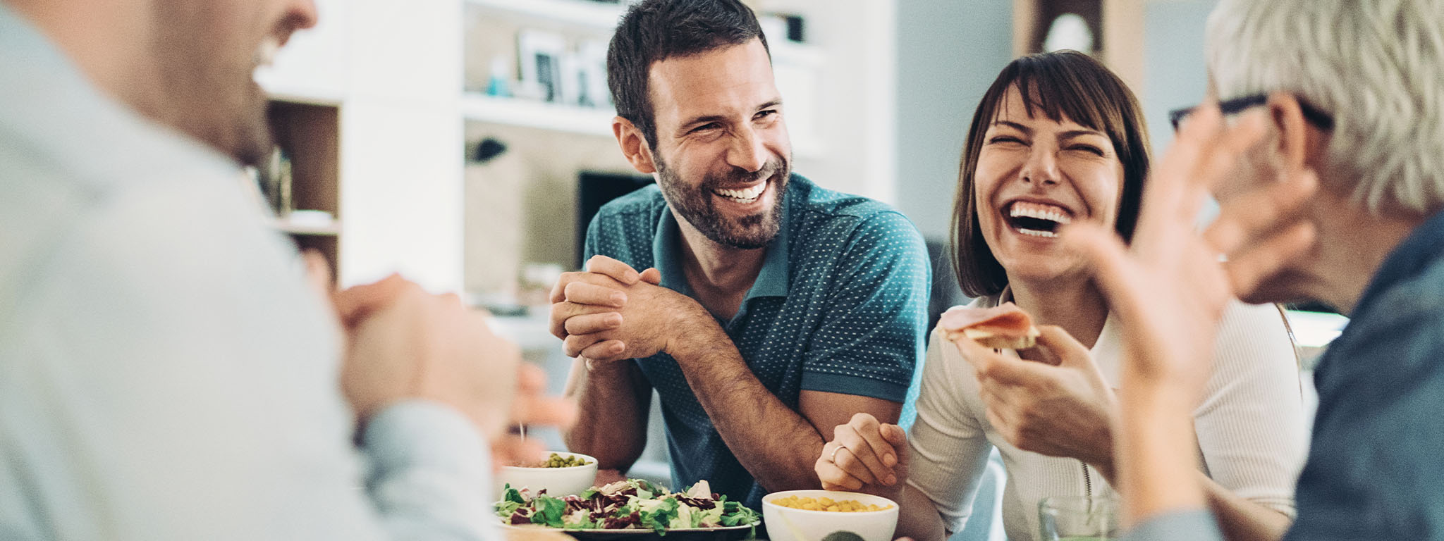 grupo de amigos à mesa a comer e a rir