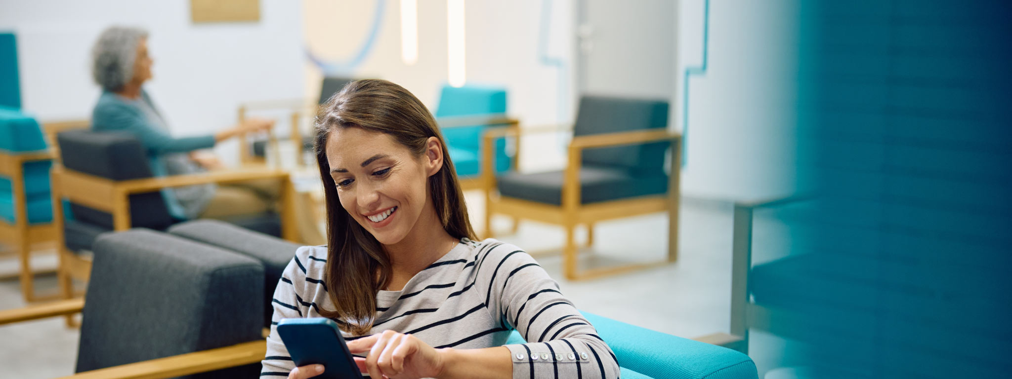  jovem mulher sorridente a usar smartphone numa sala de espera