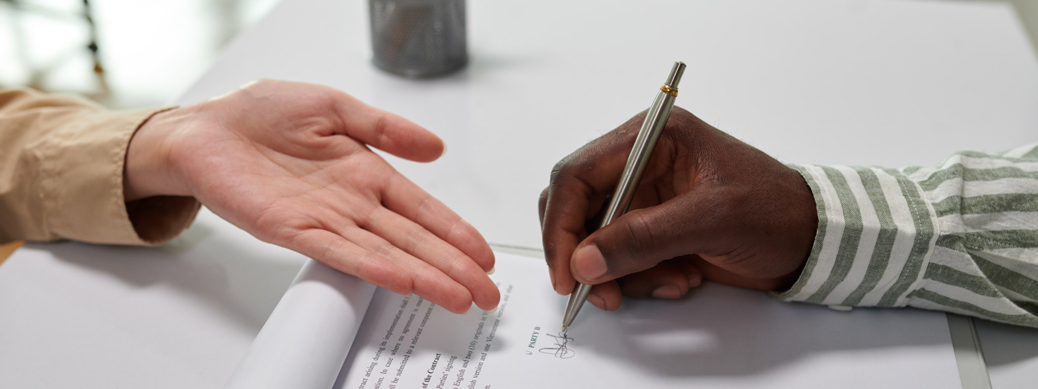  duas pessoas presentes no ato de assinar um contrato impresso