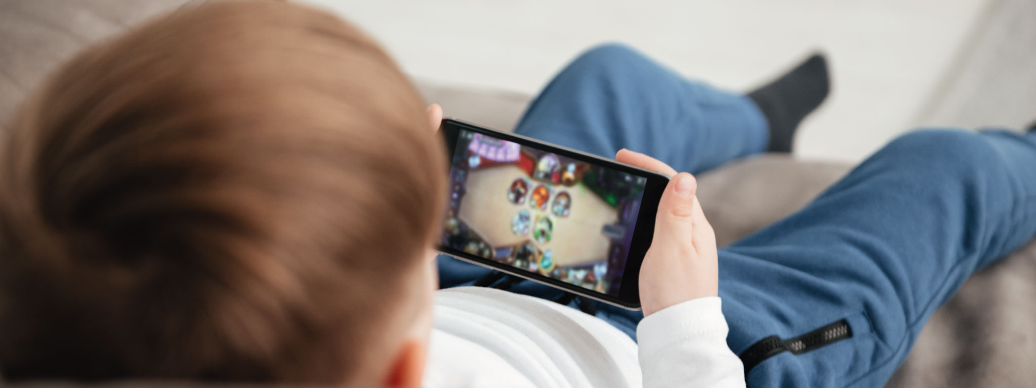 criança a jogar no telemóvel