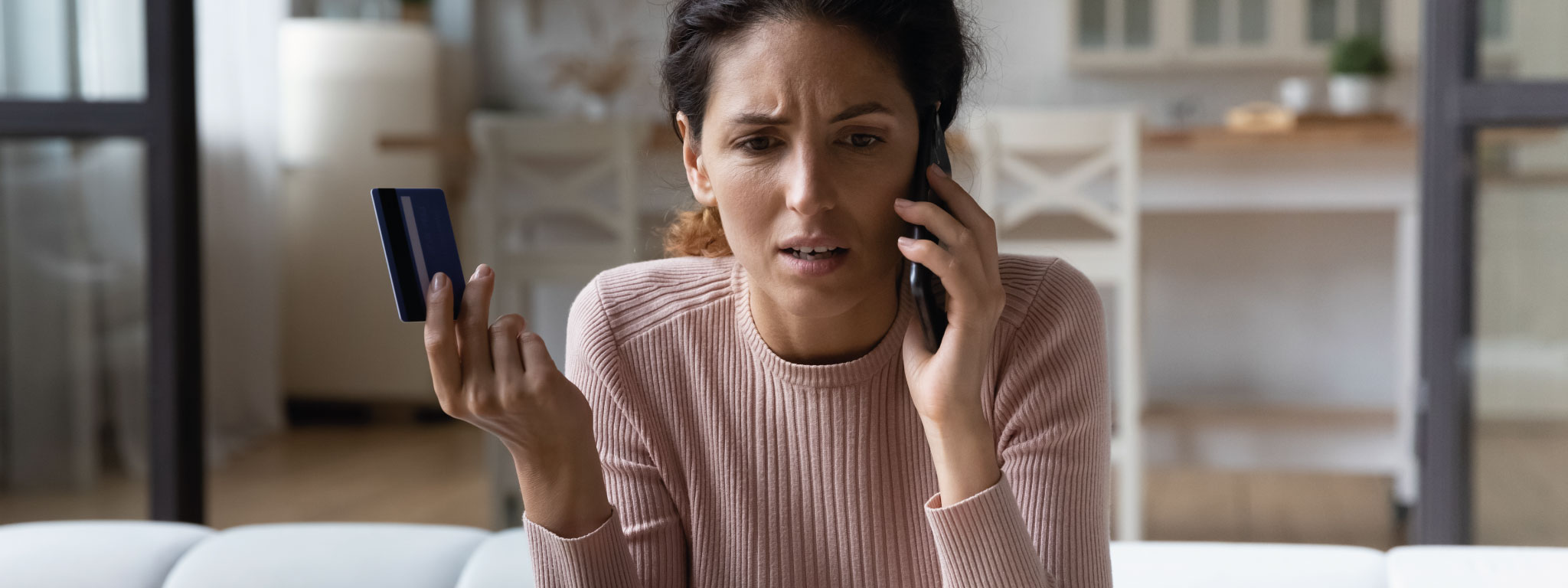 senhora ao telemóvel e com cartão de crédito na mão