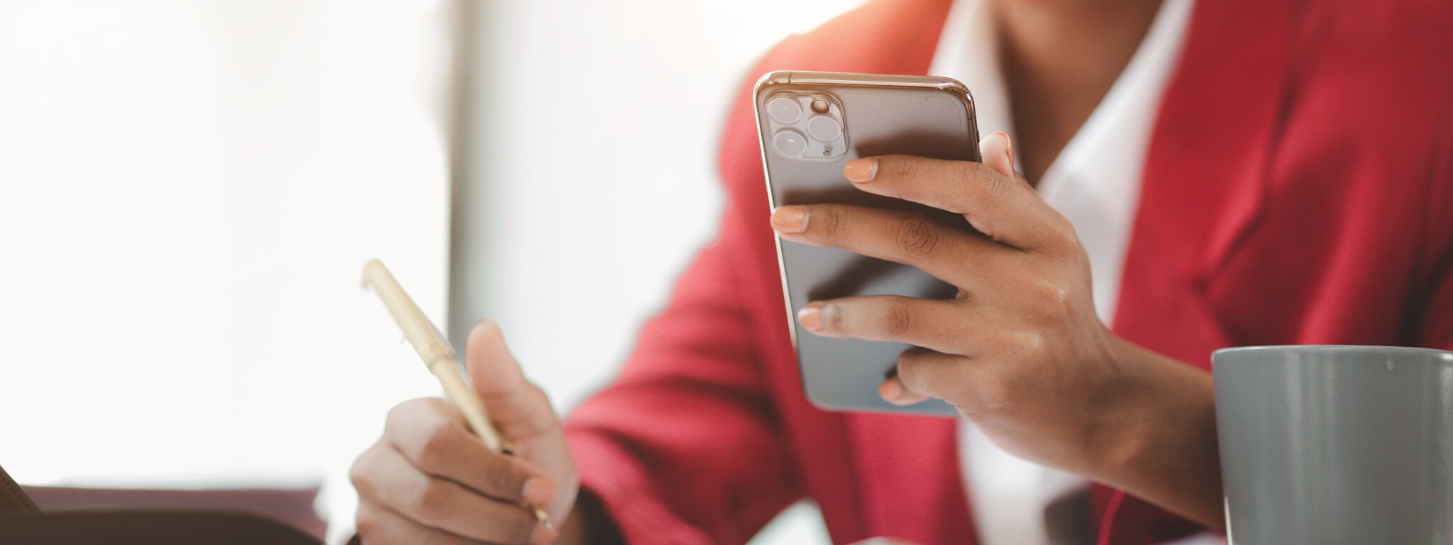 empresária com telemóvel numa mão e caneta na outra