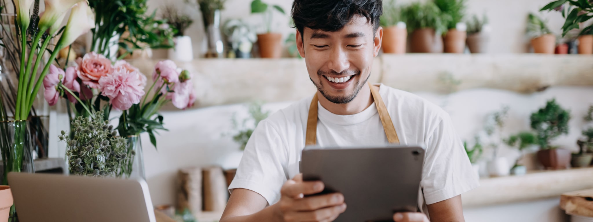 senhor a trabalhar numa florista e com um tablet na mão