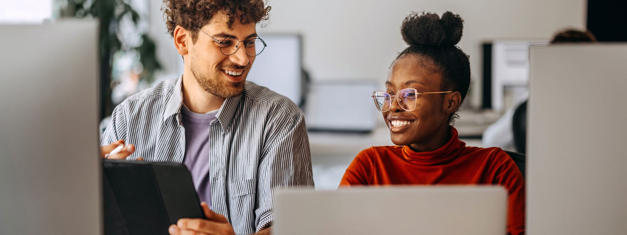 dois jovens em frente a um computador e a falarem