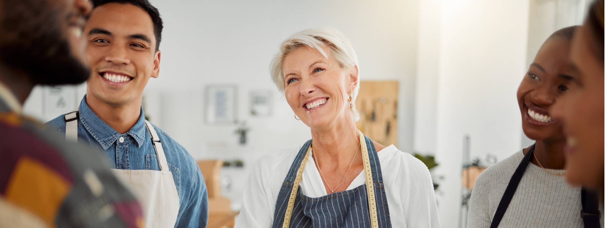  grupo de pessoas sorridentes, algumas com avental