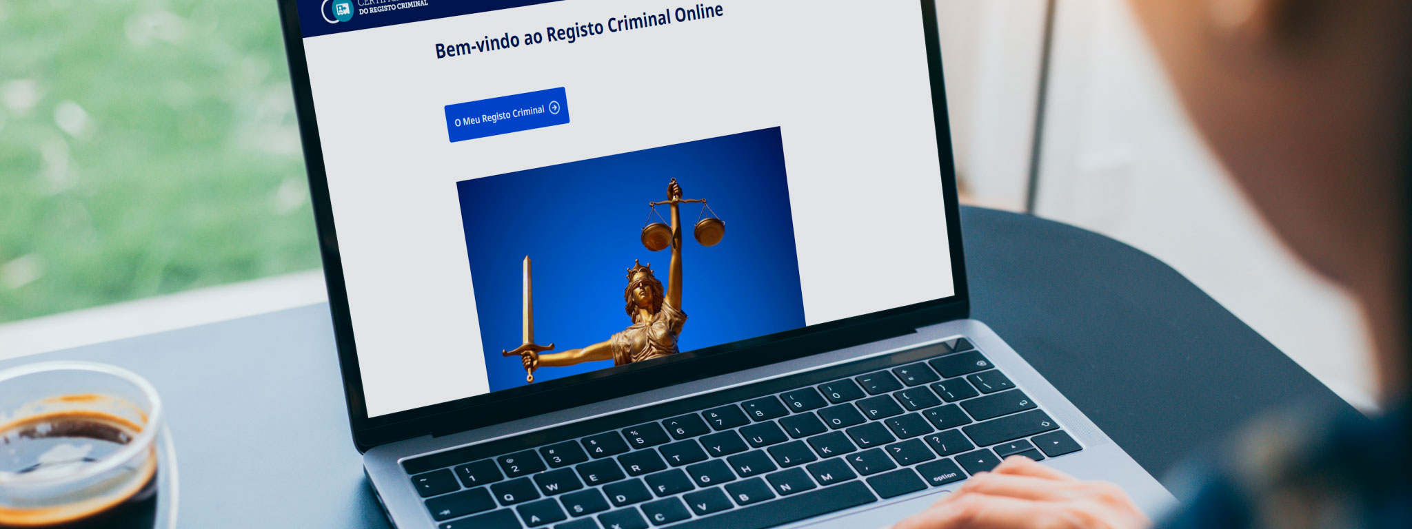 pessoa a olhar para o computador com o site para pedir registo criminal aberto
