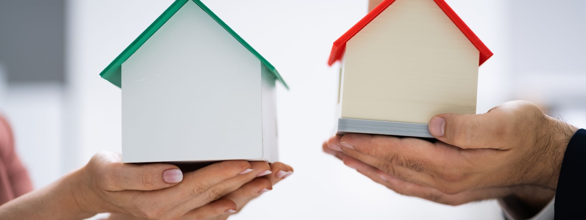 Permuta de casas particulares - pessoas a segurar uma casa nas mãos