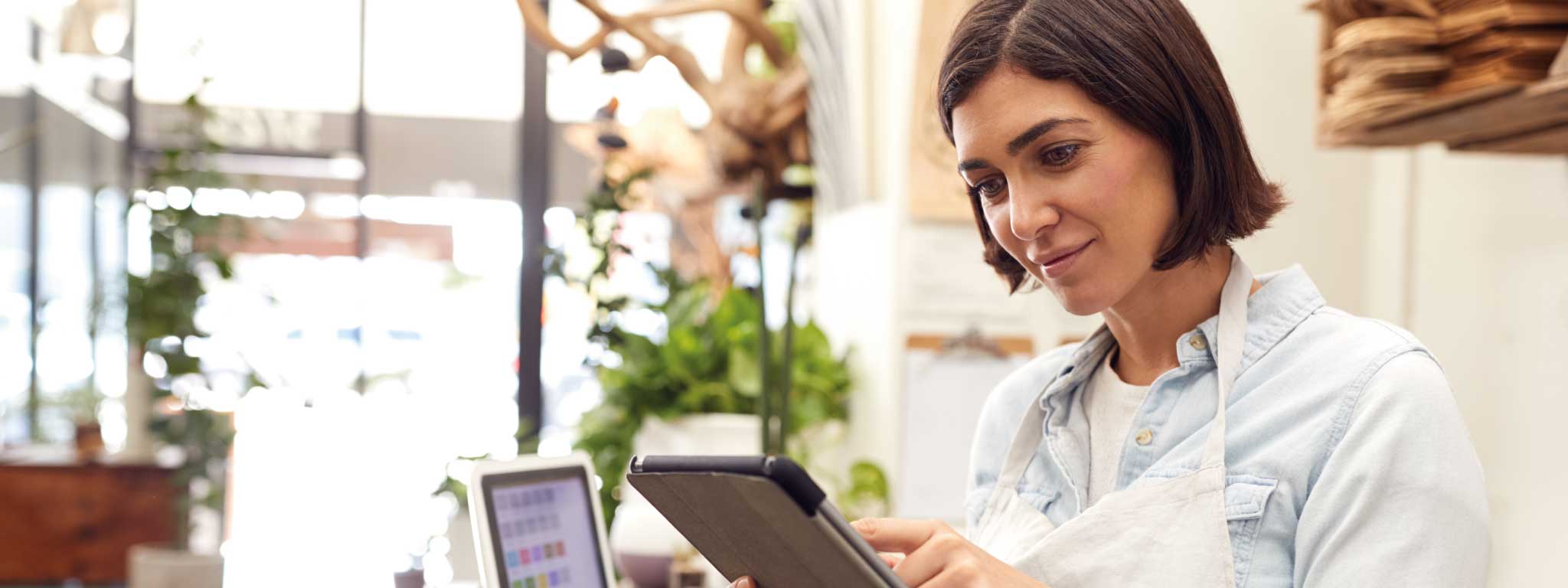senhora com tablet na mão e avental vestido