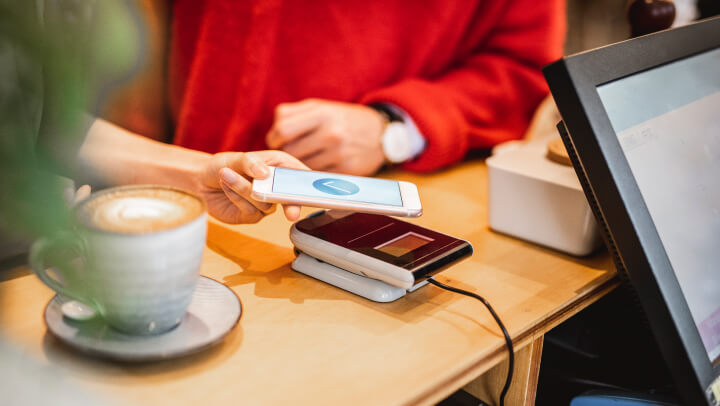 pessoa a fazer pagamento com telemóvel por contactless