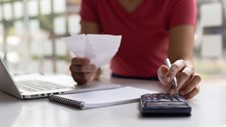 Pessoa a usar uma calculadora. Presumivelmente, para calcular a sua renda de acordo com o coeficiente de atualização do ano em causa.