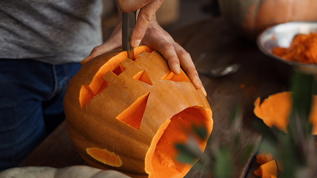 pessoa a fazer uma abóbora de Halloween