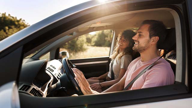 casal sentados num carro em viagem