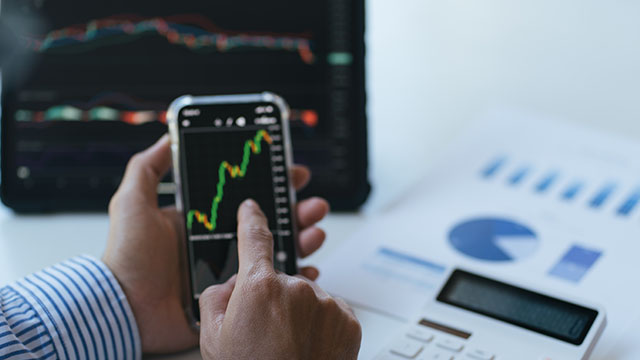 senhor a olhar para telemóvel onde mostra resultado dos investimentos
