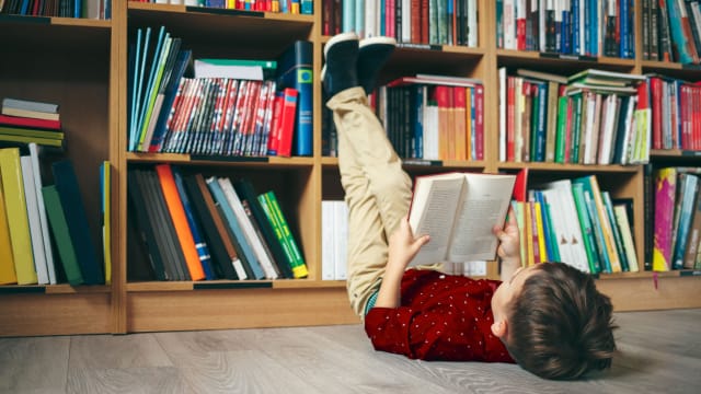 criança a ler livros infantis