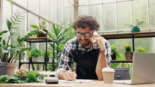 empresário ao telefone em loja de plantas