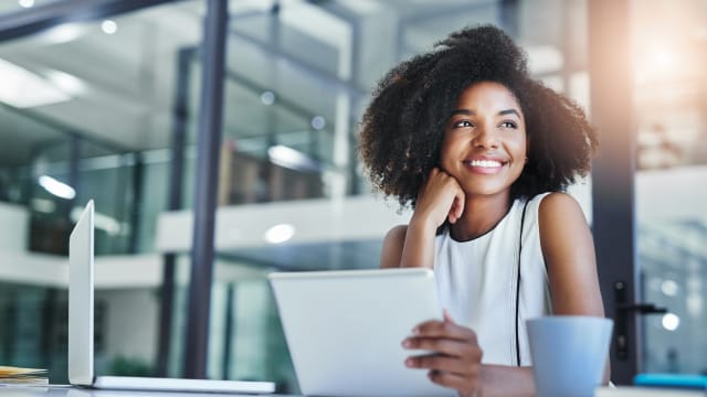 jovem a trabalhar num escritório e com ar sorridente
