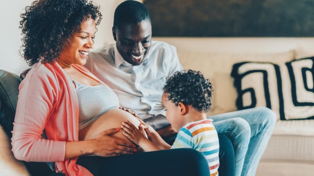 imagem de senhora grávida com filho a tocar na barriga