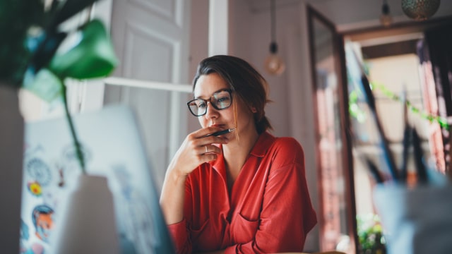 senhora a olhar com um ar sério para um computador