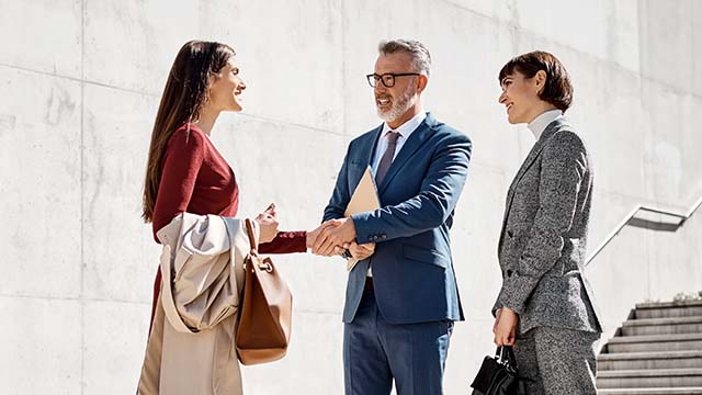 aperto de mão entre senhor e senhora em âmbito laboral