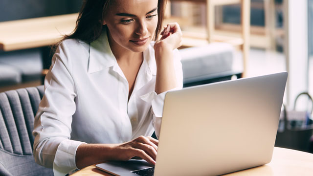 senhora em frente ao computador com um ar concentrado