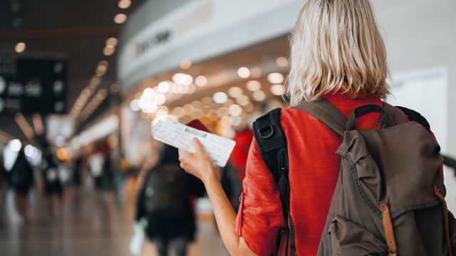 senhora com bilhete na mão no aeroporto