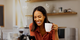 jovem mulher sorridente segura telemóvel e caneca