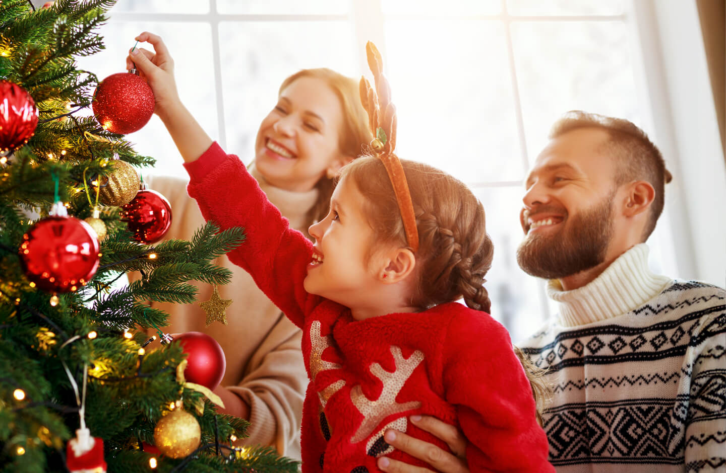 família à volta da árvore de Natal