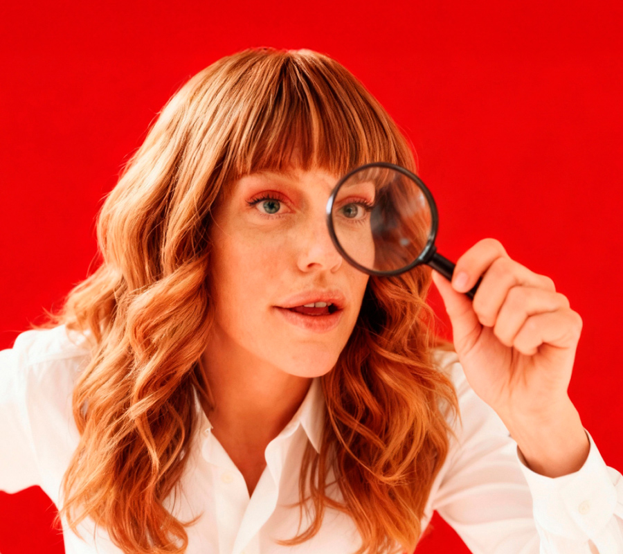 mulher a espreitar por uma lupa