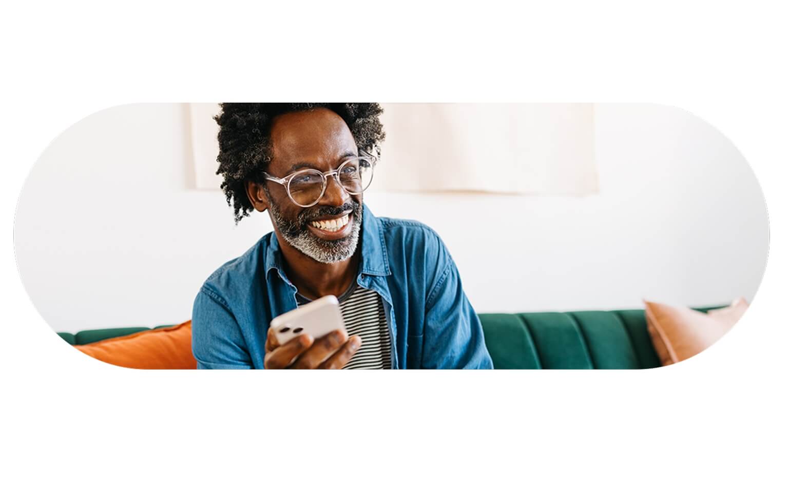 homem sorridente segura telemóvel