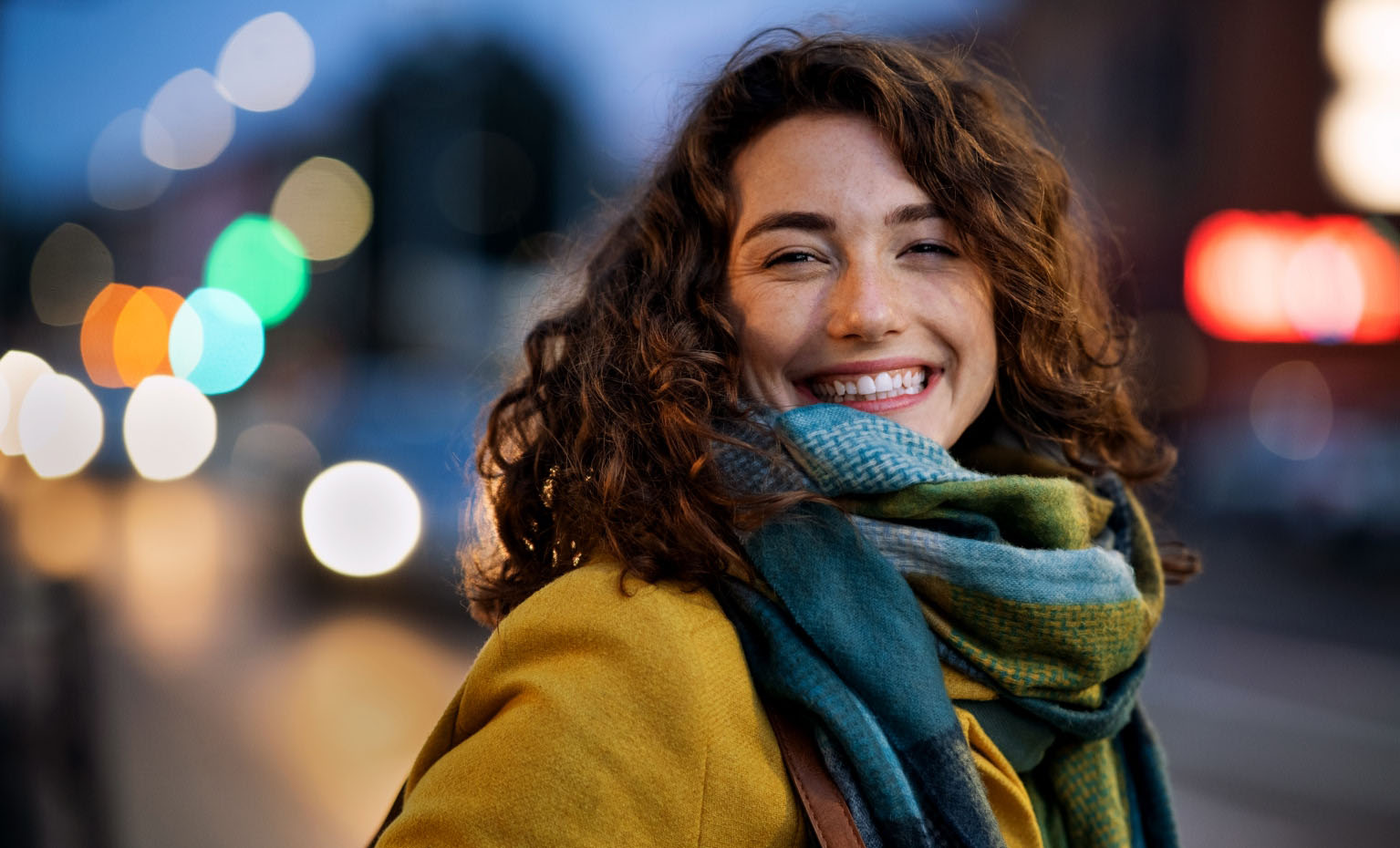 mulher sorridente agasalhada com cachecol