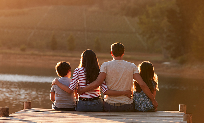 família junto ao lago abraçados