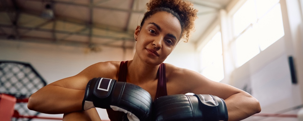 jovem mulher com luvas de boxe calçadas